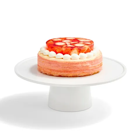 An Oishii Berry Trois Mille Crêpes cake with a strawberry gelée top, set on a white cake stand.