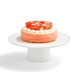 An Oishii Berry Trois Mille Crêpes cake with a strawberry gelée top, set on a white cake stand.