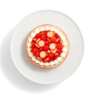 An overhead view of the Oishii Berry Trois cake with a jelly top and a border of cream dollops.