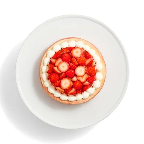 An overhead view of the Oishii Berry Trois cake with a jelly top and a border of cream dollops.