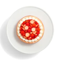 An overhead view of the Oishii Berry Trois cake with a jelly top and a border of cream dollops.