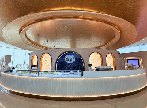 Lady M Cake Boutique at Plaza 66 in Shanghai, with a circular white counter and gold ceiling.