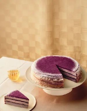 Warm image of Lady M's Purple Yam Mille Crêpes with a slice removed.