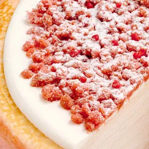 Close-up of a Lady M Pink Pearl Mille Crêpes. Crêpe layers, cream, and strawberry streusel & pearls.