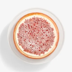 A top-down shot of a Lady M Pink Pearl Mille Crêpes set on top a white cake stand.