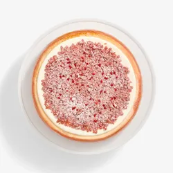 A top-down shot of a Lady M Pink Pearl Mille Crêpes set on top a white cake stand.