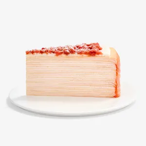 A Lady M Pink Pearl Mille Crêpes slice set on top a white round cake plate.