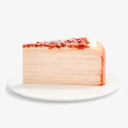 A Lady M Pink Pearl Mille Crêpes slice set on top a white round cake plate.