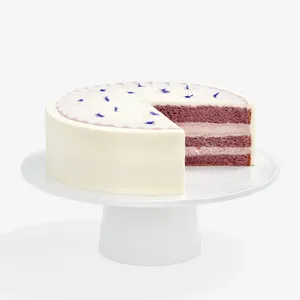 A sliced into Lady M Taro Mochi Cream Cake set on top a white cake stand.