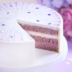 An overhead close-up of a Lady M Taro Mochi Cream Cake, set on top a white cake stand.