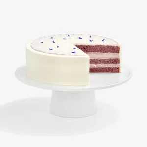 A sliced into Lady M Taro Mochi Cream Cake set on top a white cake stand.
