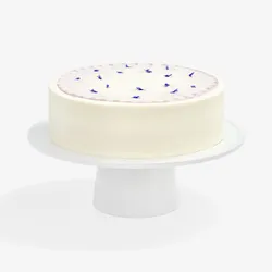 A Lady M Taro Mochi Cream Cake set on top a white cake stand.