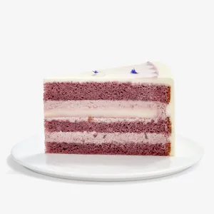 A Lady M Taro Mochi Cream Cake slice set on top a white round cake plate.