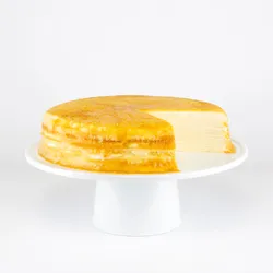 A sliced into Lady M Gluten-Free Signature Mille Crêpes on top a white cake stand.