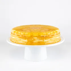 A Lady M Gluten-Free Signature Mille Crêpes on top a white cake stand.