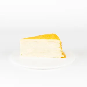 A Lady M Gluten-Free Signature Mille Crêpes slice on top a white round plate.