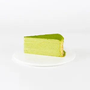 A Lady M Gluten-Free Green Tea Mille Crêpes slice on top a white round plate.