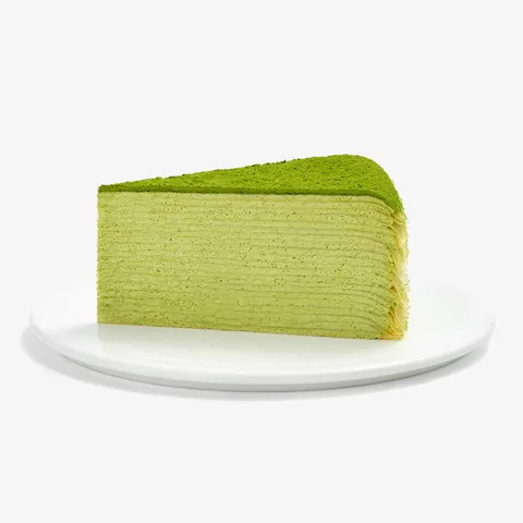 A Lady M Gluten-Free Green Tea Mille Crêpes slice on top a white round plate.