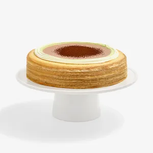 A Lady M Coffee Matcha Mille Crêpes on top a white cake stand.