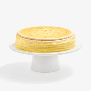 A Lady M Carrot Cake Mille Crêpes on top a white cake stand.
