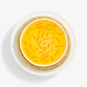 A top-down shot of a Lady M Carrot Cake Mille Crêpes on top a white cake stand.