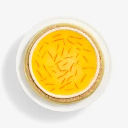 A top-down shot of a Lady M Carrot Cake Mille Crêpes on top a white cake stand.