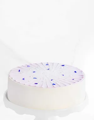 Lady M's whole Taro Mochi Cream Cake on a white cake stand.