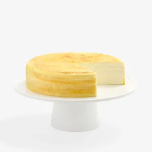 A sliced into Lady M Gluten-Free Signature Mille Crêpes on top a white cake stand.
