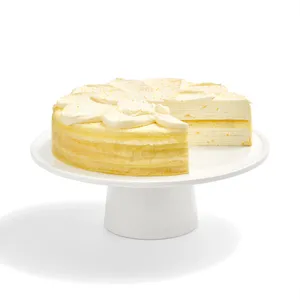 A sliced into Lady M Orange Mille Crepes cake on a white cake stand.