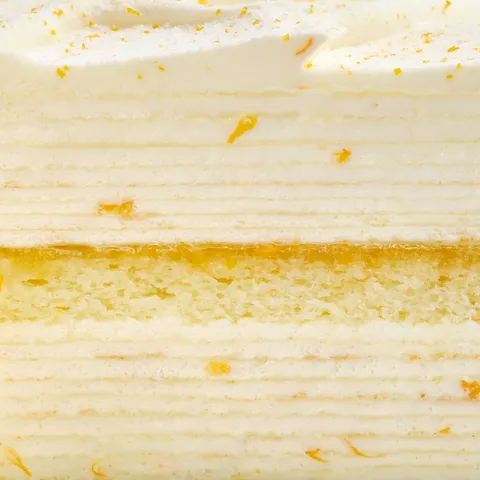 Detail shot of a Lady M Orange Mille Crepes. Layers of crepes, sponge, and orange marmalade.