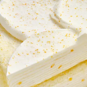 A close-up shot of a Lady M Orange Mille Crepes showing the top and interior of the cake.