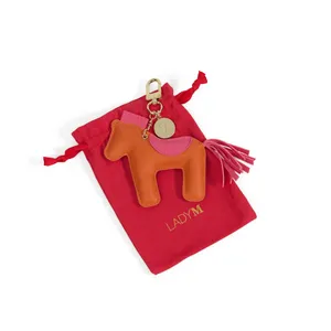 Lady M's 2026 Year of the Horse Vegan Leather Bag Charm with red dust bag.