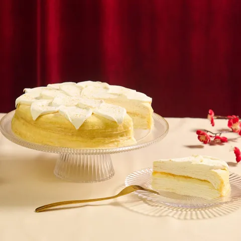 Lady M’s Orange MC sliced and served on a glass plate against a red fabric backdrop.