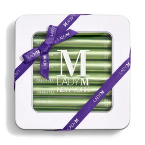 Lady M's Green Tea Crêpe Biscuits with a logo on the top lid and a blue ribbon.