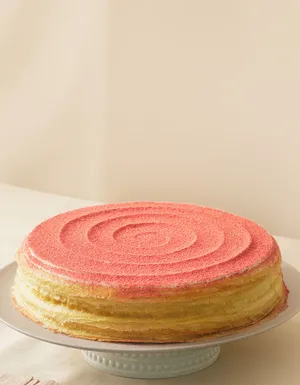 Lady M's Strawberry Swirl Mille Crêpes with a beige background.