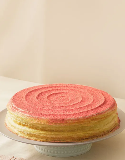 Lady M's Strawberry Swirl Mille Crêpes with a beige background.