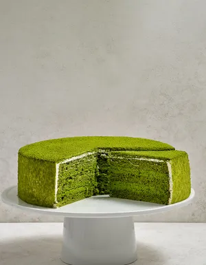 Lady M's Green Tea Mousse sliced into revealing matcha sponge and mousse layers.