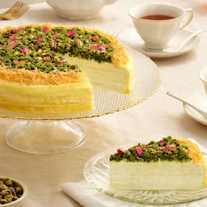 Lady M's Baklava Mille Crêpes cake with pistachios and rose petals, served with a slice and tea.