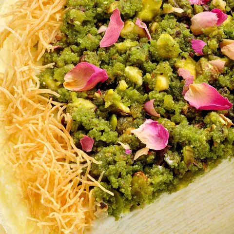 Lady M's Baklava Mille Crêpes topped with crushed pistachios, rose petals, and crisp kataifi.