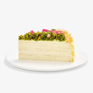 Slice of Lady M's Baklava Mille Crêpes topped with pistachios, rose petals, and kataifi.