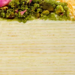 Close-up of Lady M's Baklava Mille Crêpes layers with crêpes, cream, pistachio, rose, and kataifi.