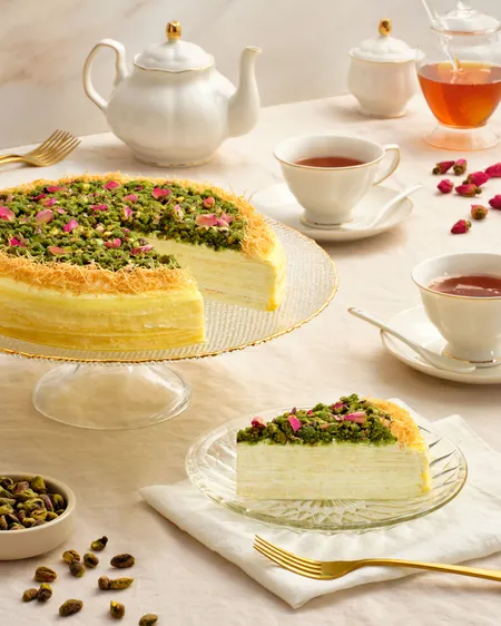Lady M's Baklava Mille Crêpes topped with pistachios and rose petals, served with tea.