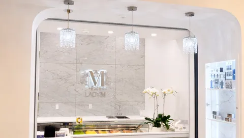Lady M's Tangram pop-up featuring marble walls, chandeliers, cakes, and bon bons.
