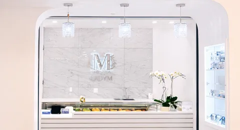 Lady M's Tangram boutique with marble walls, chandeliers, cakes, and bon bons.