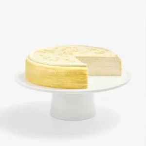Osmanthus Mille Crêpes cake with slice removed, revealing elegant floral cream layers and glossy finish
