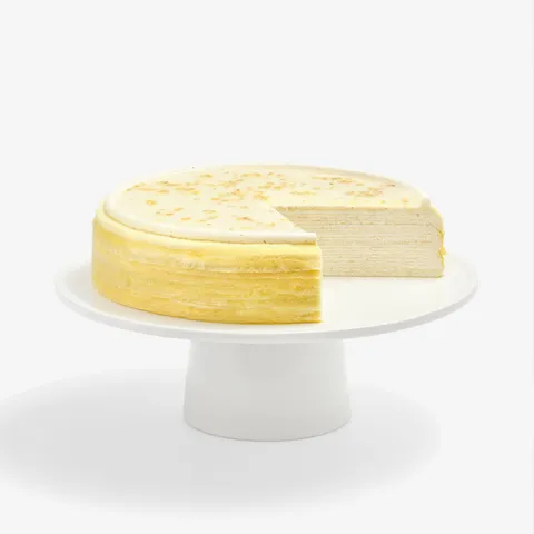 Osmanthus Mille Crêpes cake with slice removed, revealing elegant floral cream layers and glossy finish