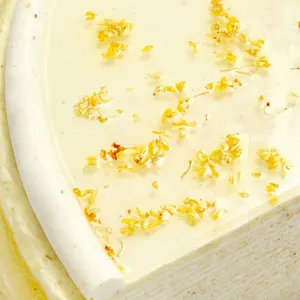 Close-up detail of glossy Osmanthus Mille Crêpes glaze topped with delicate edible osmanthus blossoms