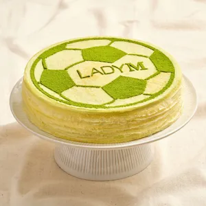 World Cup Green Tea Mille Crêpes decorated with a soccer ball matcha stencil design.