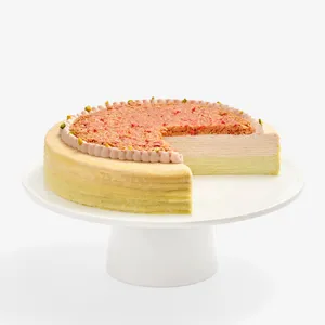 Dubai Strawberry Mille Crêpes with a slice removed, revealing the cream and crêpe layers.