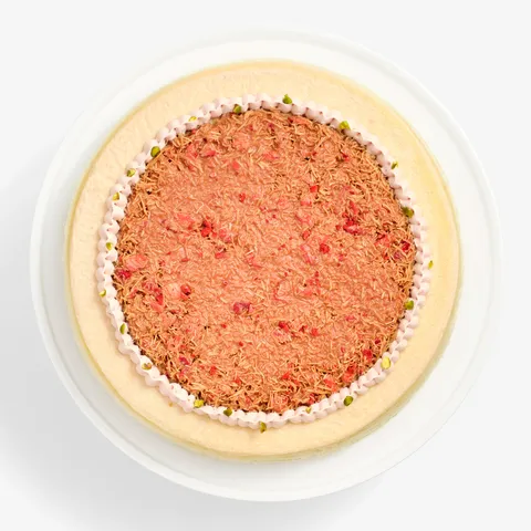 Overhead view of Dubai Strawberry Mille Crêpes topped with strawberry kataifi and pistachio pieces.